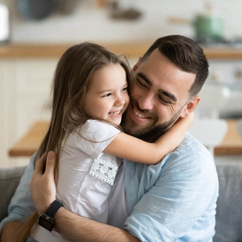 Close up smiling loving young father hugging adorable little daughter